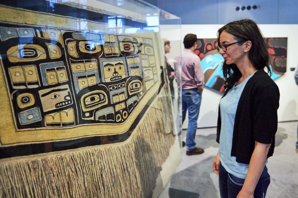 Women looking at Sonny Assu Exhibit