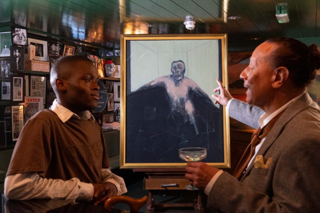 Two men talking in a London Pub, in between them is a painting by Francis Bacon called Study for Portrait of P.L., no. 2, 1957, oil on canvas.